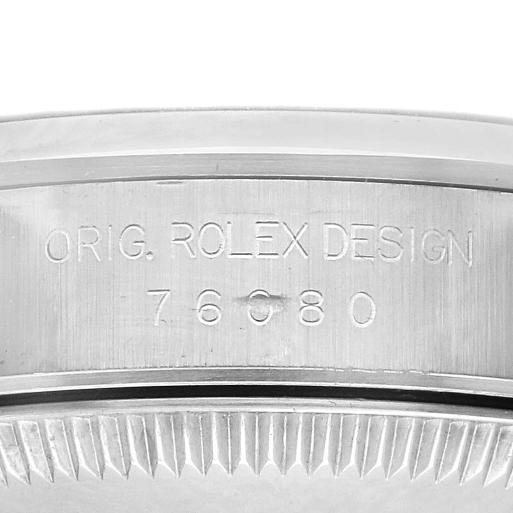 The image shows a close-up of the side engraving on a Rolex Oyster Perpetual 76080 Women's Stainless Steel Pink Dial 76080 Women's Stainless Steel Pink Dial watch, highlighting the design number.