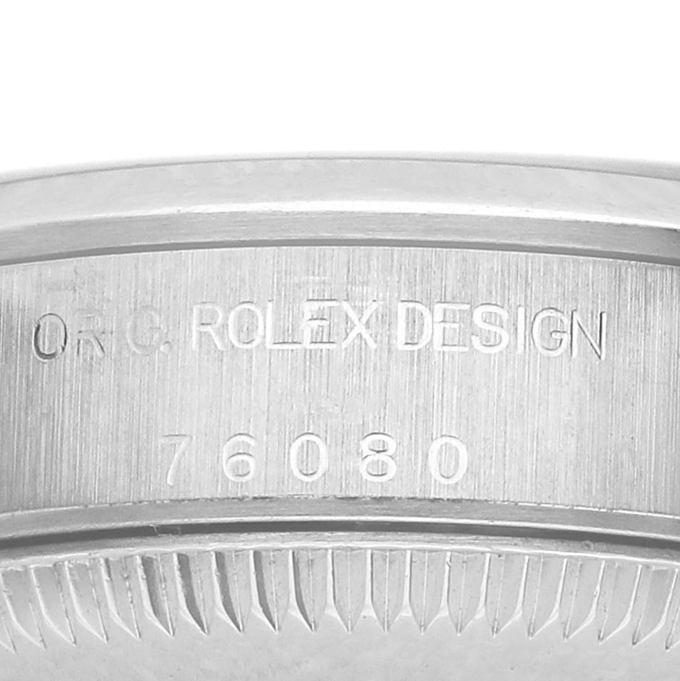 The image shows a close-up of the side engraving on a Rolex Oyster Perpetual 76080 Women's Stainless Steel White Dial 76080 Women's Stainless Steel White Dial watch, featuring the model number and branding.