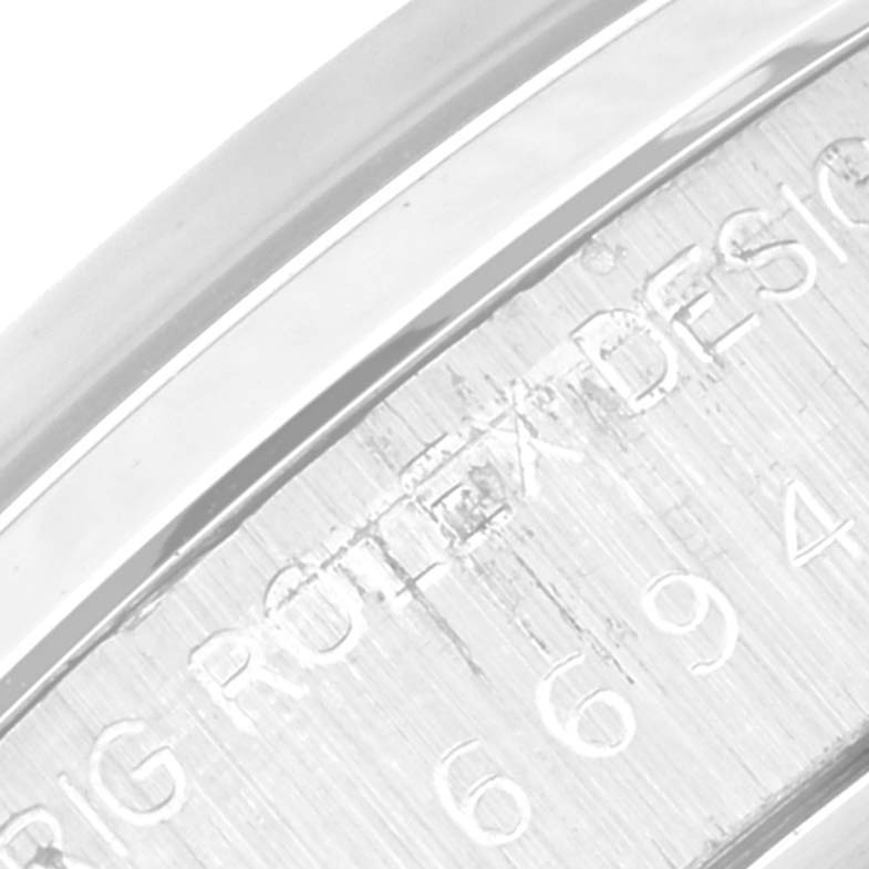 The image shows a close-up of the engraved bezel and part of the case back on a Vintage Collection Rolex watch.