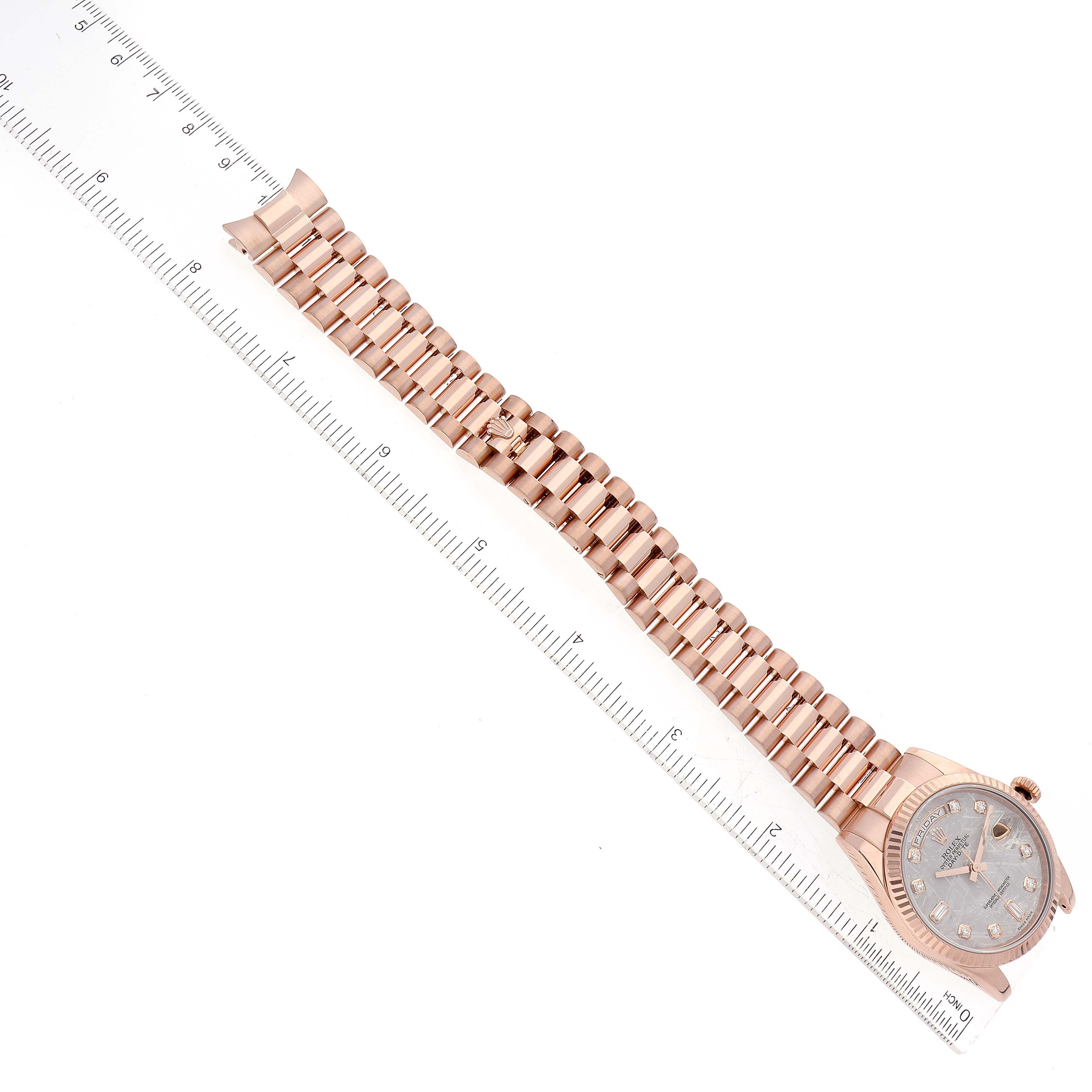 The image shows a Rolex President 118235 Men's Rose Gold Silver Dial 118235 Men's Rose Gold Silver Dial model watch laid flat, with the full bracelet and the face partially visible, alongside a ruler for scale.