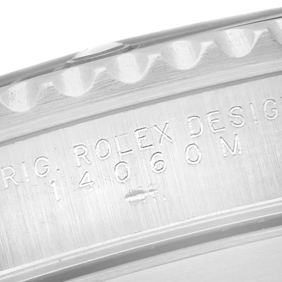 The image shows the edge and engraved serial number of a Rolex Submariner 14060 Men
s Stainless Steel Black Dial 14060 Men
s Stainless Steel Black Dial watch, focusing on the case side.
