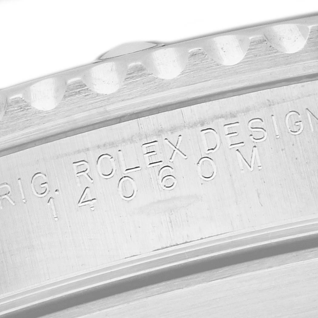 The image shows a close-up of the bezel and engraved case back of a Rolex Submariner 14060 Men
s Stainless Steel Black Dial 14060 Men
s Stainless Steel Black Dial watch.