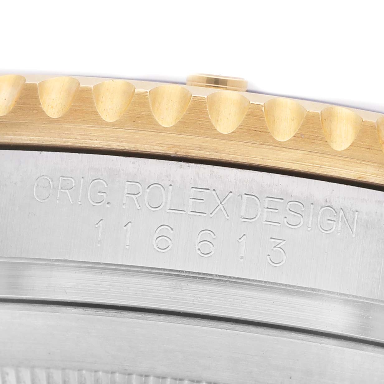 The image shows a close-up of the side of a Rolex Submariner 116613 Men's Steel and Gold (two tone) Blue Dial, featuring its engraved model number and bezel teeth.