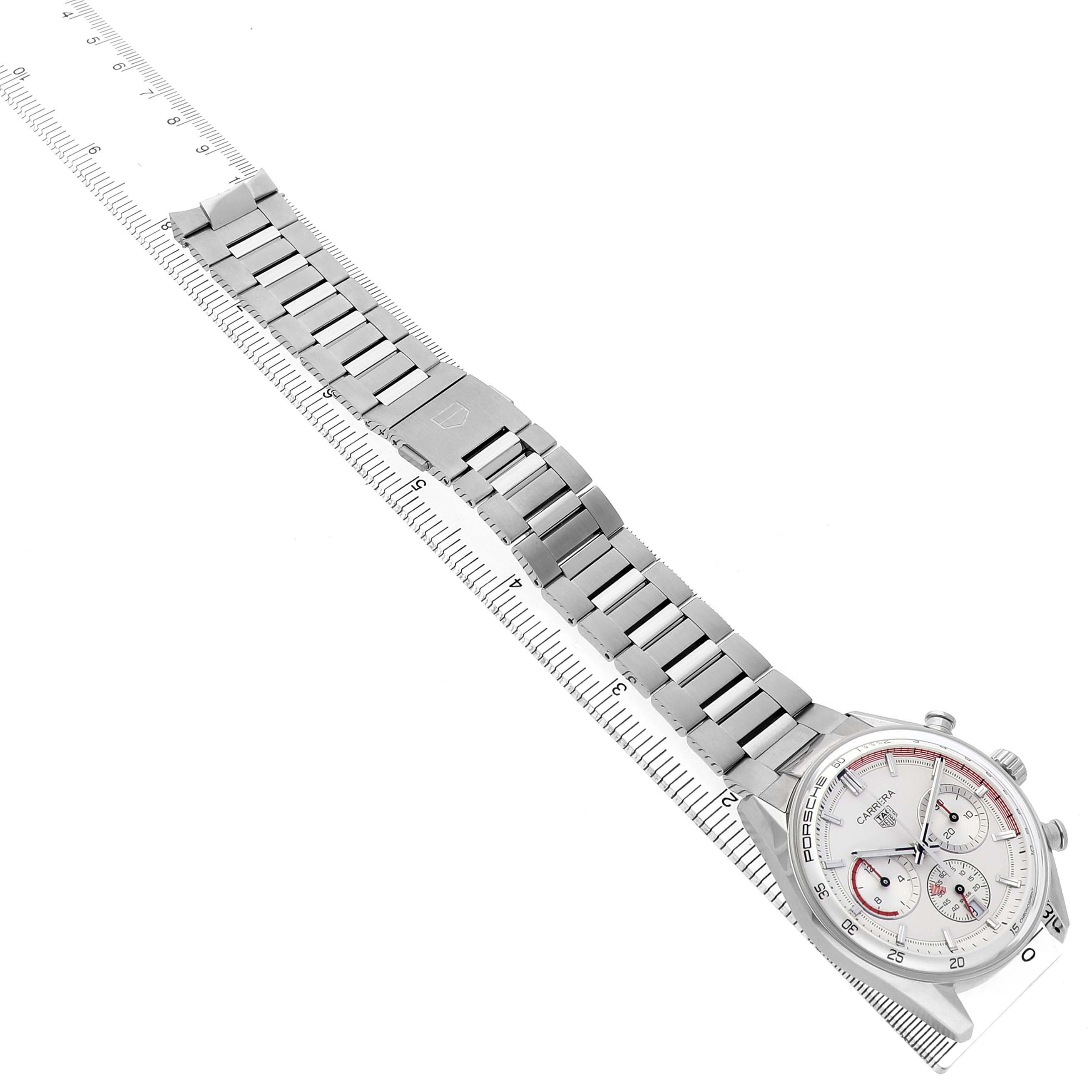 The Tag Heuer Carrera CBS2011.FC6529 Men's Stainless Steel Silver Dial watch is shown from a top-down angle, highlighting its silver bracelet and dial, placed alongside a ruler.