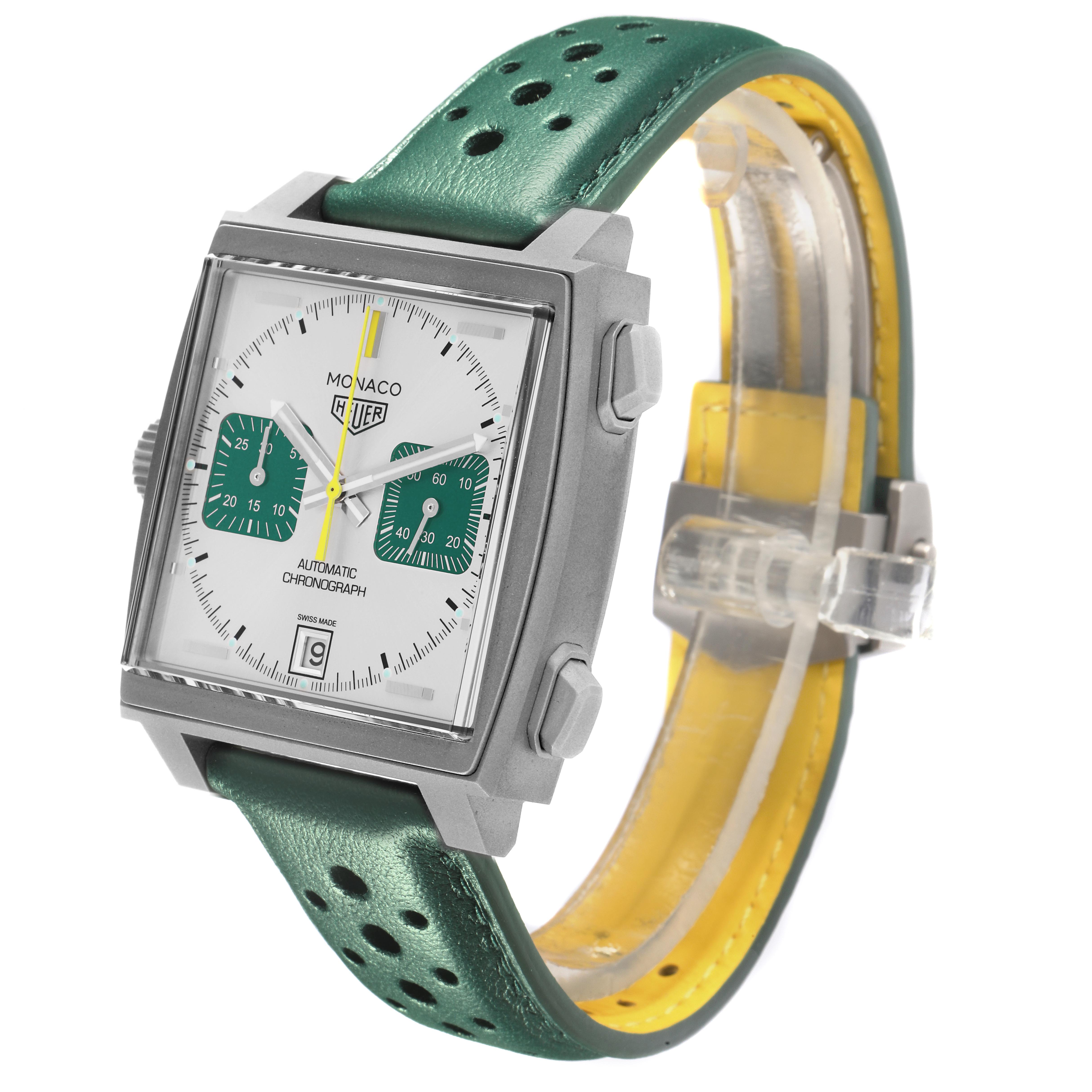 The image shows a Tag Heuer Monaco CAW218E.FC6565 Men's Titanium Silver Dial CAW218E.FC6565 Men's Titanium Silver Dial watch at a three-quarter angle, displaying the face, side buttons, and perforated green strap.