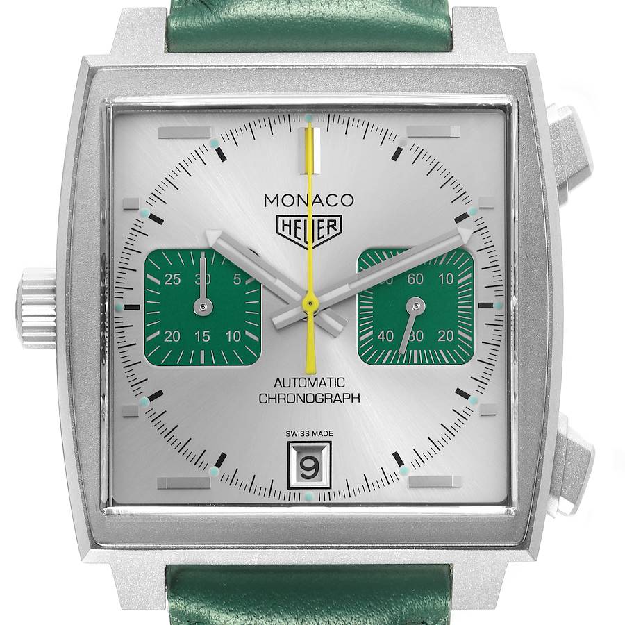 The Tag Heuer Monaco watch is shown from the front, displaying its dial, green subdials, and crown on the left side.