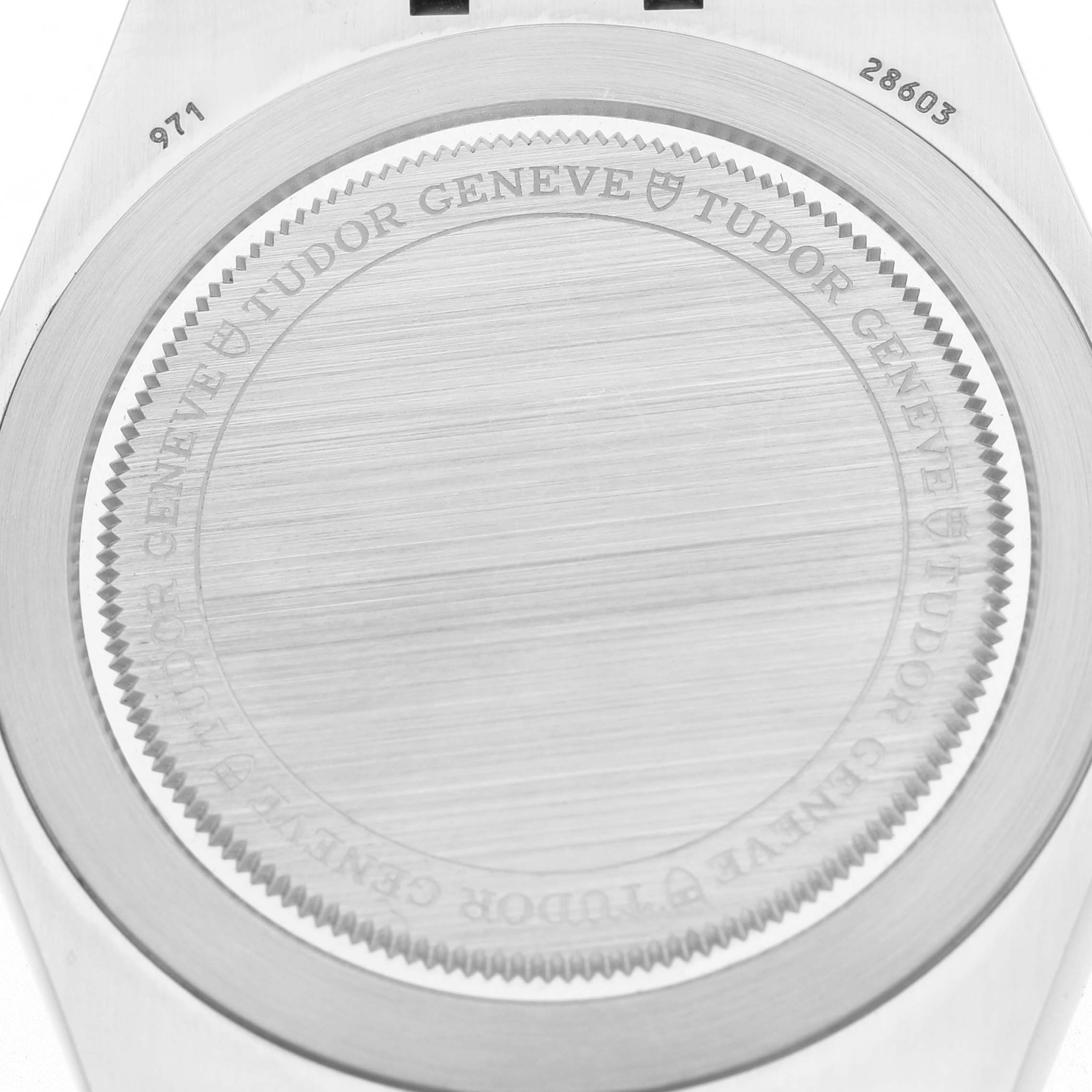 The image shows the back case of a Tudor Royal 28603 Men's Stainless Steel Champagne Dial watch from a top-down angle, highlighting its engravings and brushed finish.