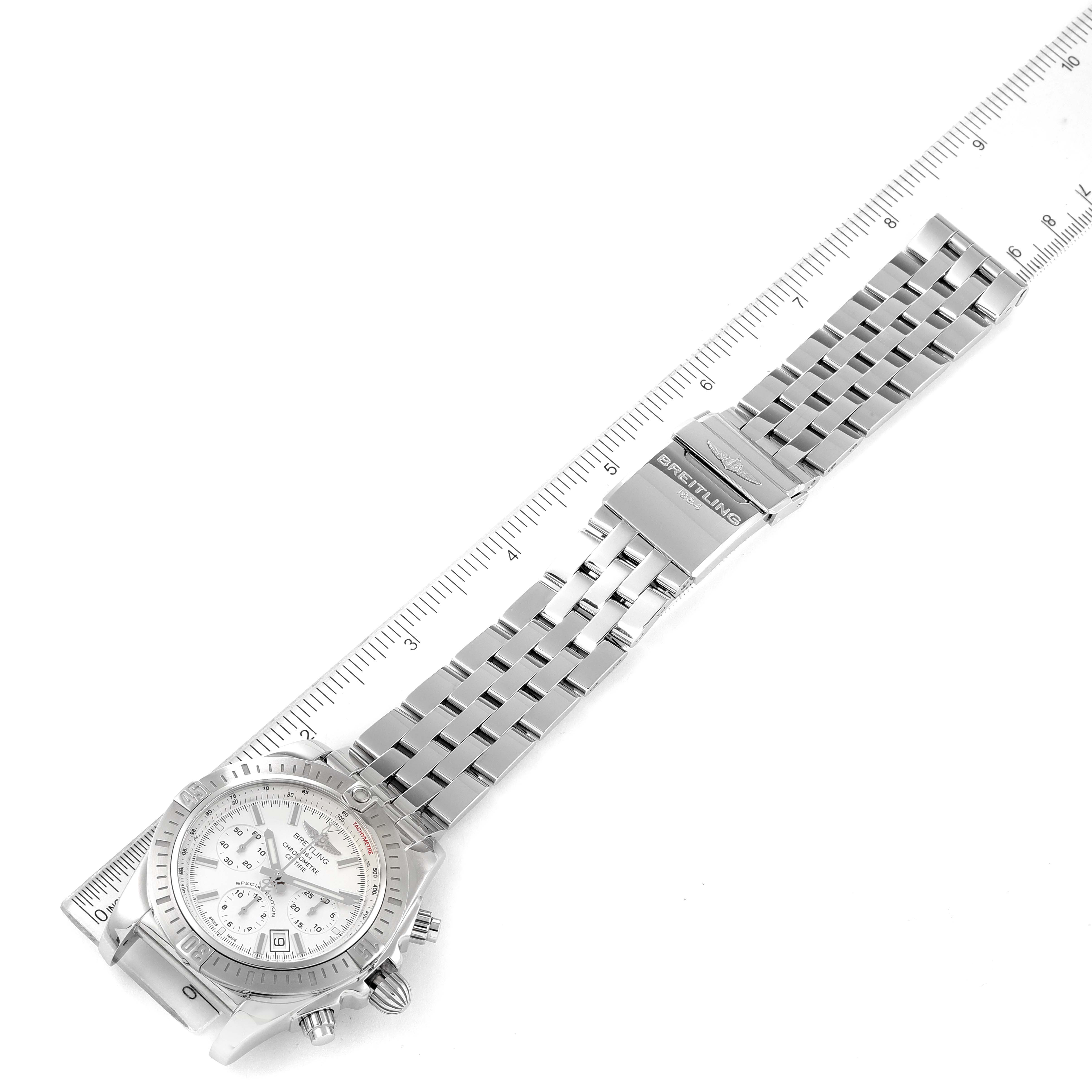 The image shows a Breitling Chronomat AB0115 Men
s Stainless Steel Silver Dial AB0115 Men
s Stainless Steel Silver Dial watch laid flat with its stainless steel band fully extended and a ruler placed alongside.
