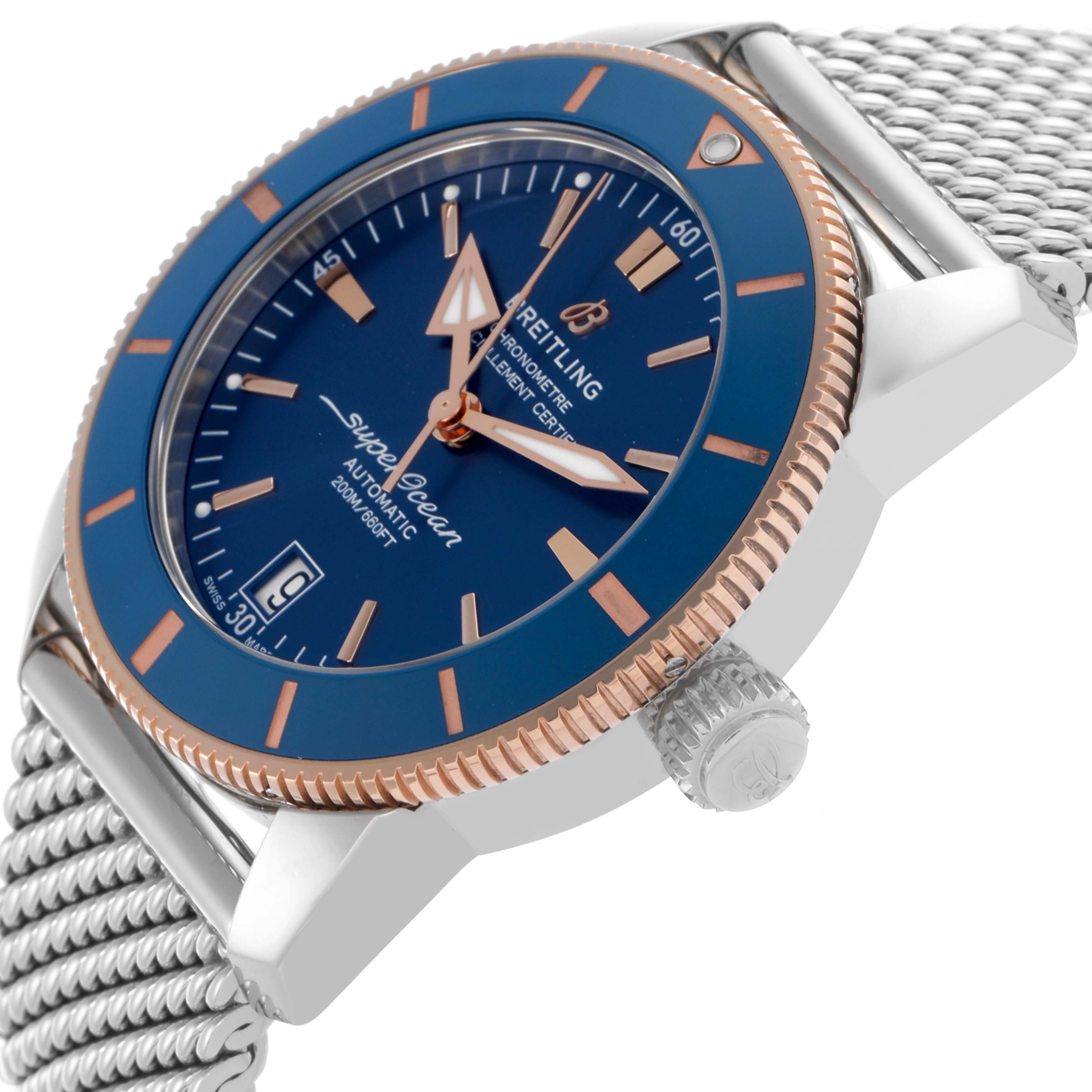 The Breitling Superocean UB2010161C1A1 Men's Stainless Steel Blue Dial UB2010161C1A1 Men's Stainless Steel Blue Dial watch is shown from a side angle, highlighting the blue dial, rose gold bezel, and mesh bracelet.