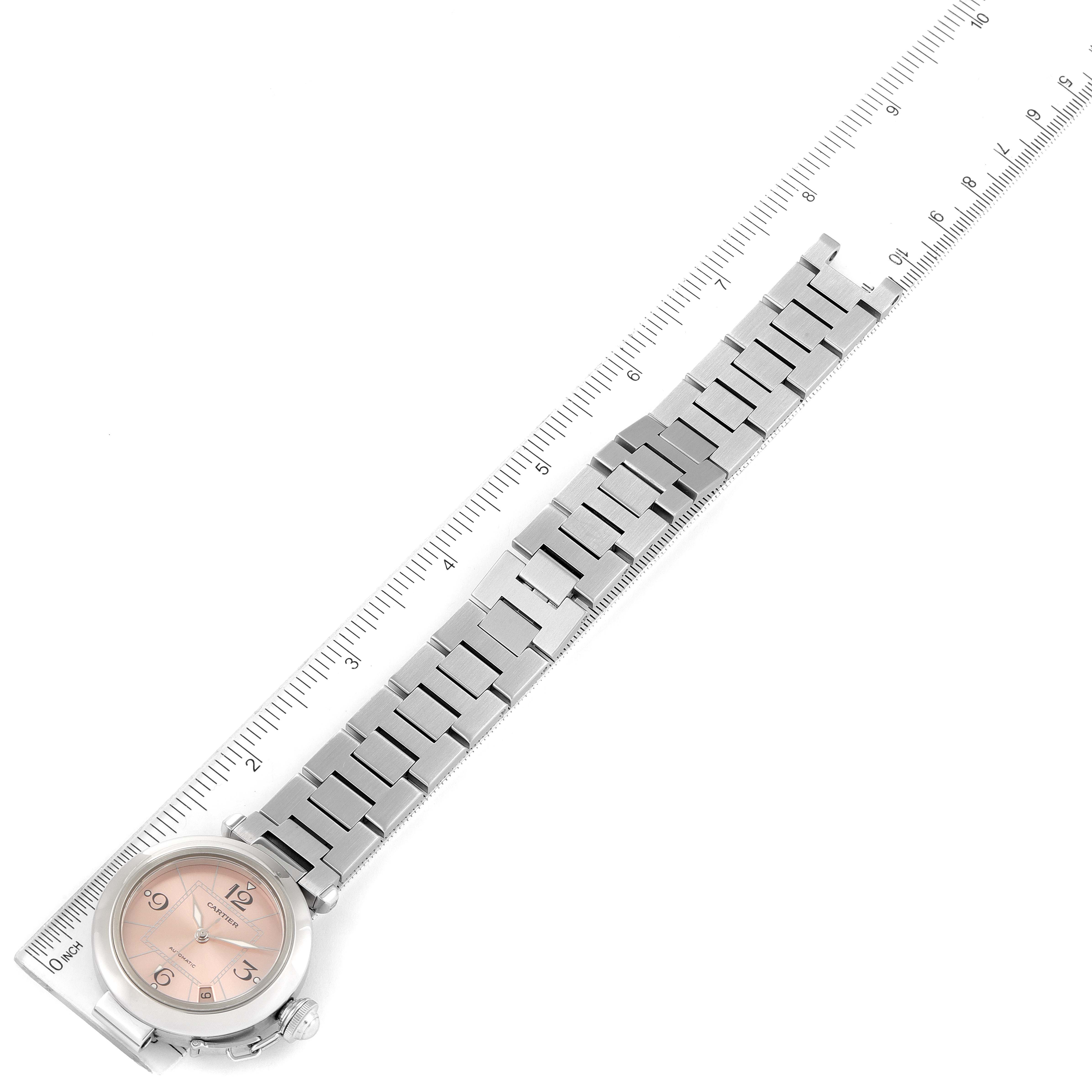The image shows a Cartier Pasha W31075M7 Women's Stainless Steel Pink Dial W31075M7 Women's Stainless Steel Pink Dial watch laying flat with its metal bracelet extended alongside a ruler for measurement.