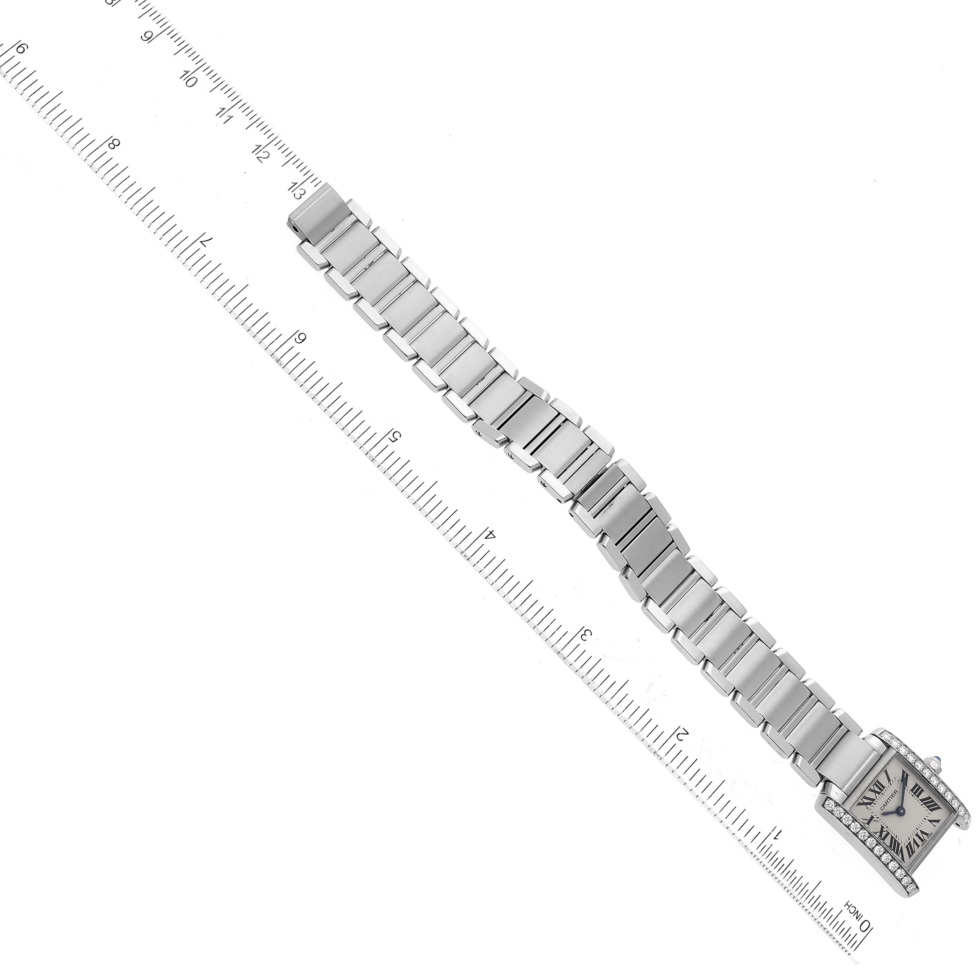 This image shows the Cartier Tank Française watch laid flat, with a ruler adjacent to its bracelet for size reference.