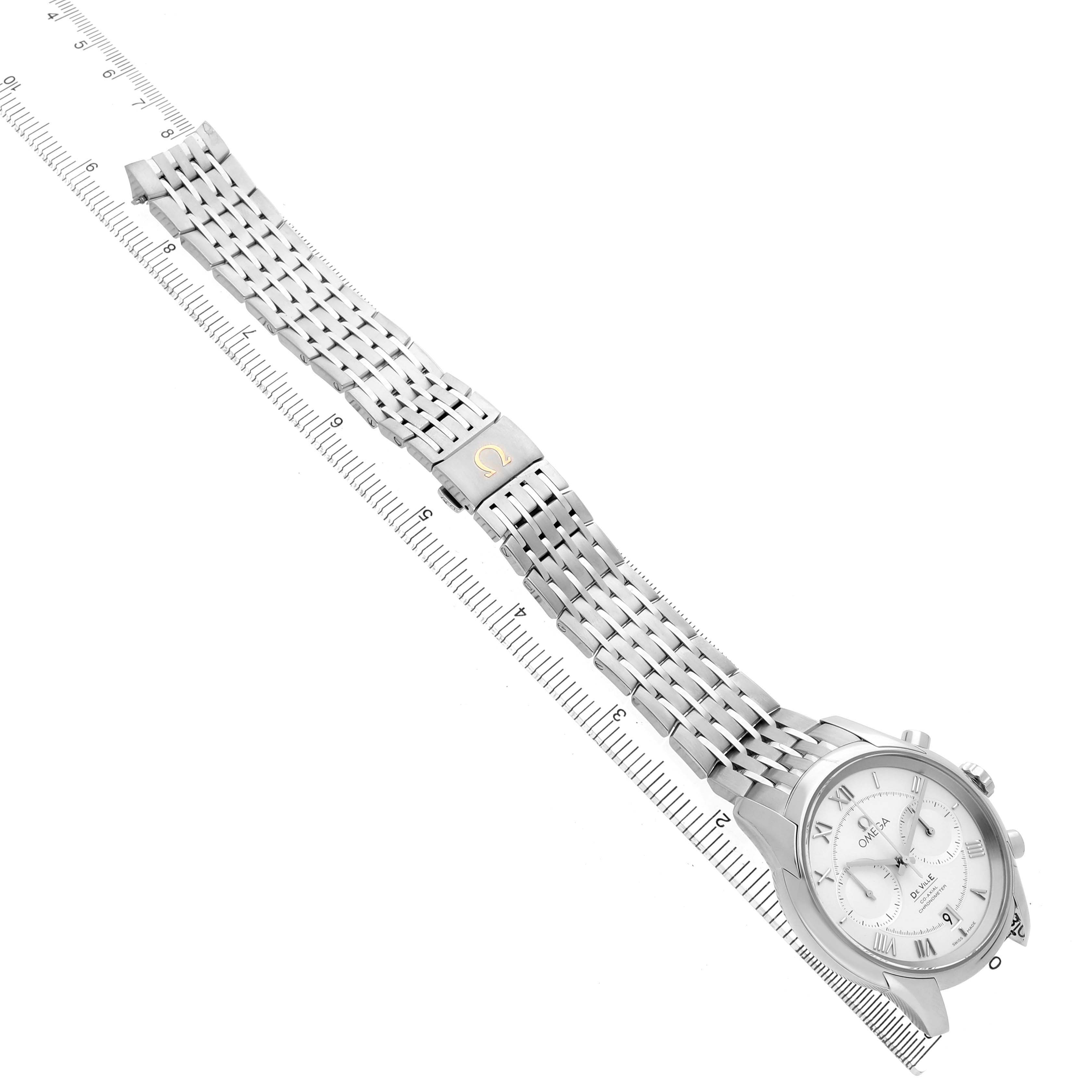 The Omega De Ville 431.10.42.51.02.001 Men's Stainless Steel Silver Dial watch is shown from a top angle, displaying the dial, case, bracelet, and clasp with a ruler for scale.