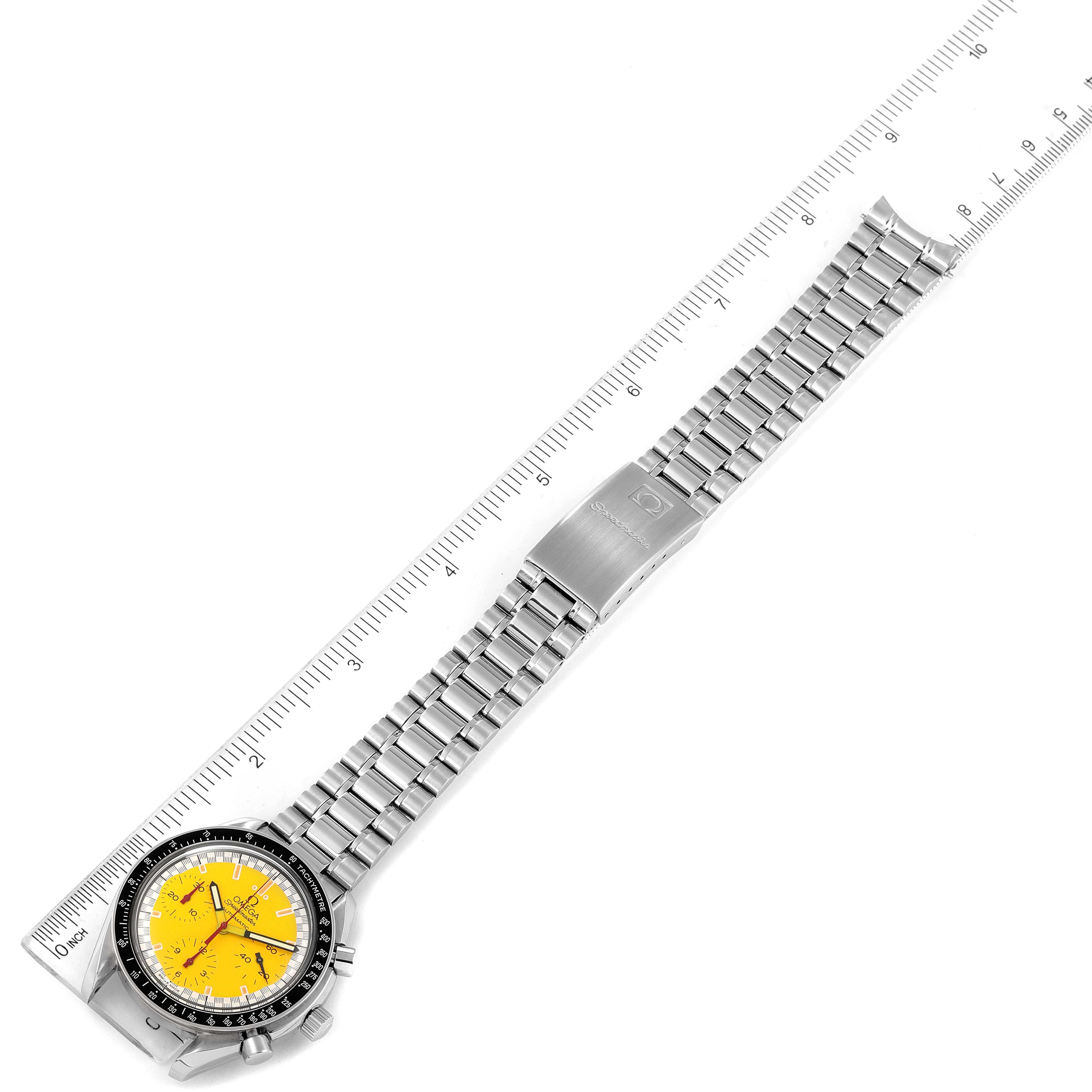 The Omega Speedmaster 3510.12.00 Men's Stainless Steel Yellow Dial 3510.12.00 Men's Stainless Steel Yellow Dial watch is shown lying flat with its metallic strap extended and aligned with a ruler for measurement.