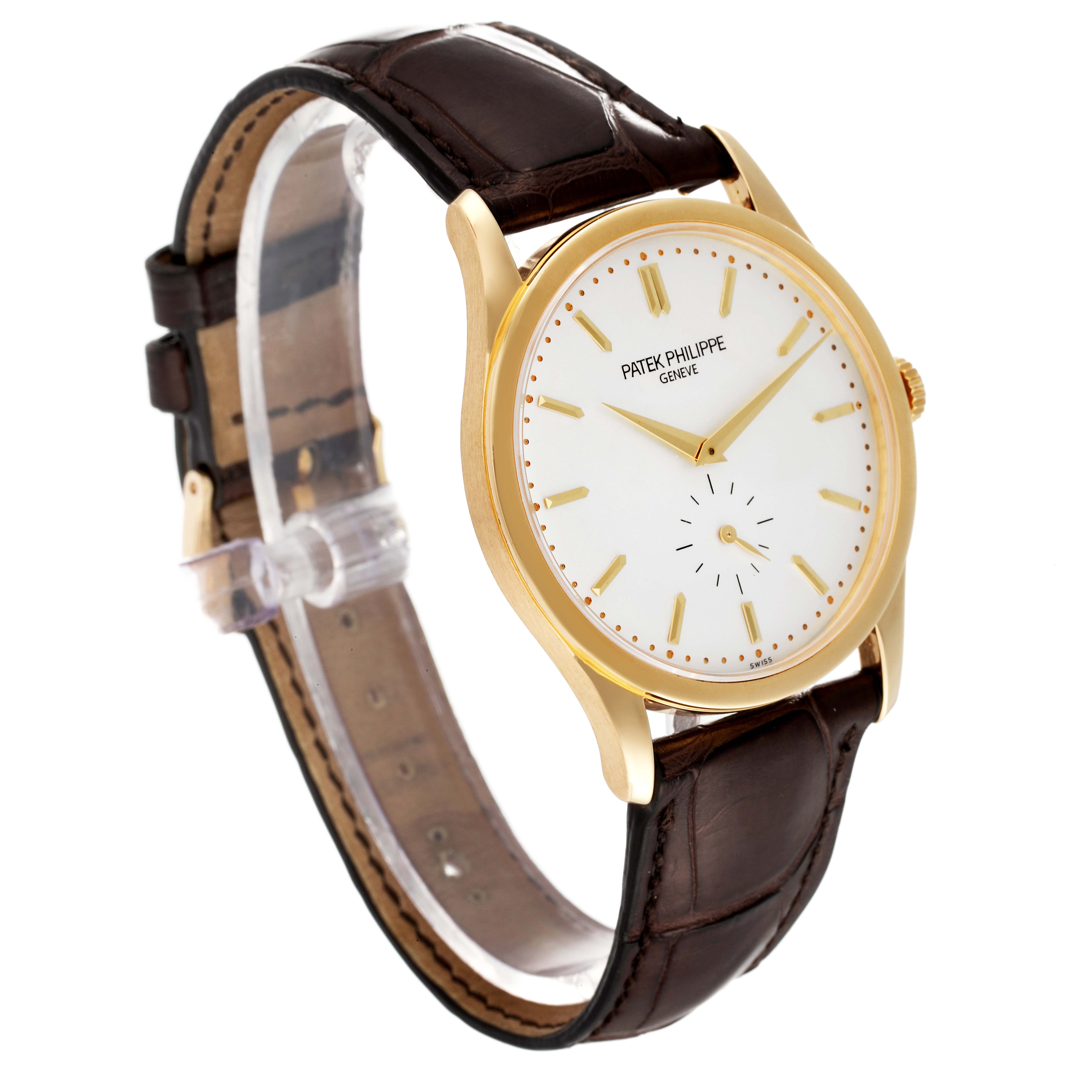 The image shows a side-angle view of a Patek Philippe Calatrava 5196J Men's Yellow Gold Silver Dial 5196J Men's Yellow Gold Silver Dial watch featuring a brown leather strap and a gold case with a white dial.