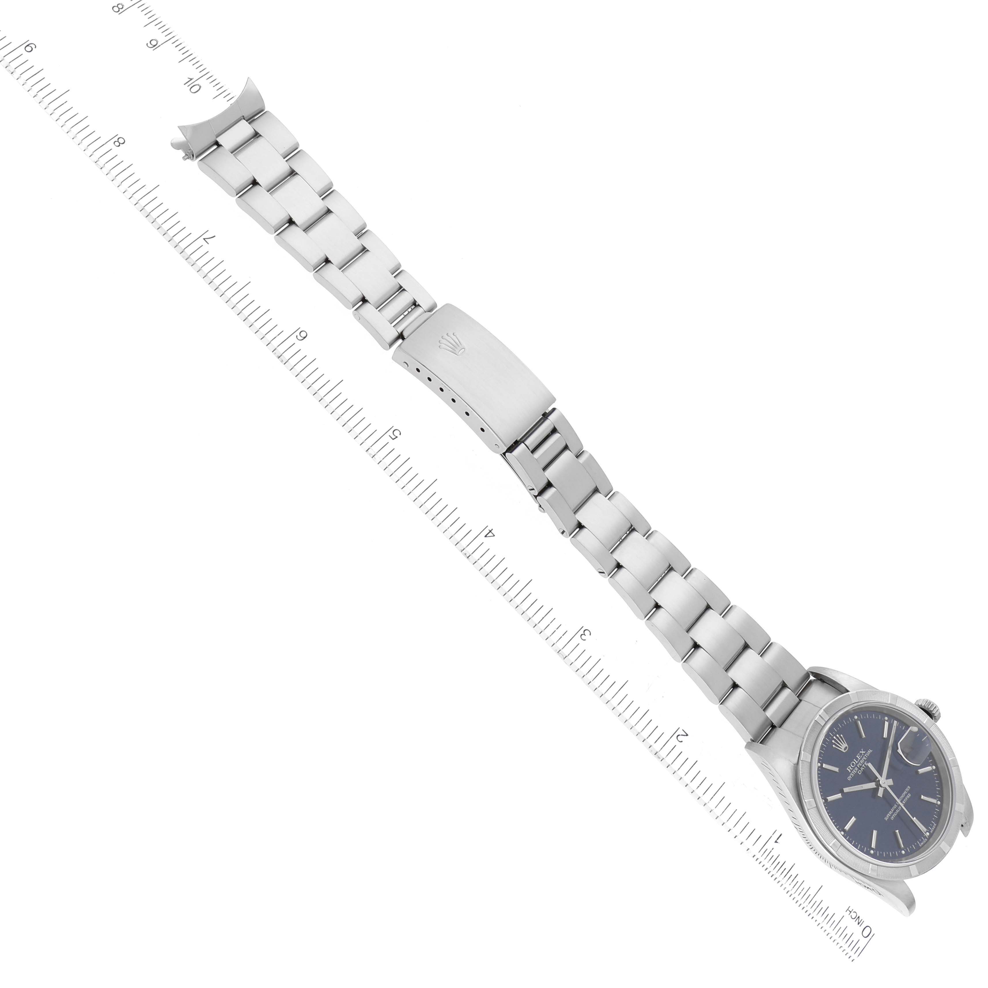The Date model by Rolex is shown in a top-down angle, displaying the watch face, bracelet, and clasp alongside a ruler.