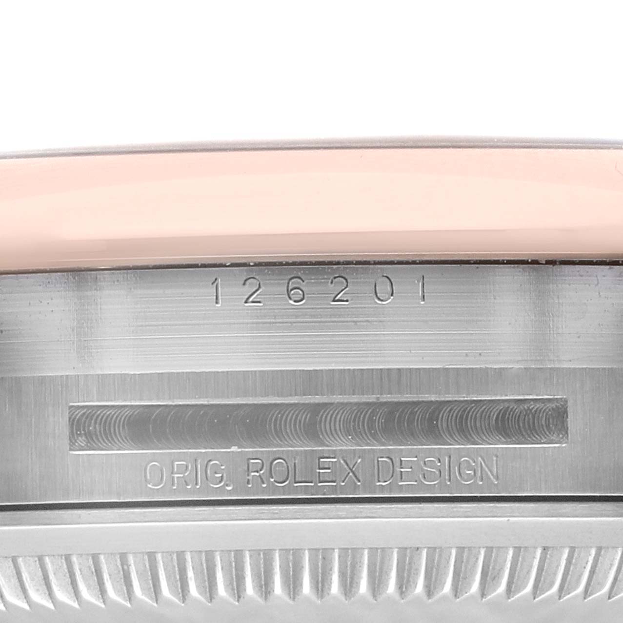 This image shows a close-up of the Rolex Datejust 126201 Men's Steel and Gold (two tone) Grey Dial 126201 Men's Steel and Gold (two tone) Grey Dial model's bezel and serial number engraving.