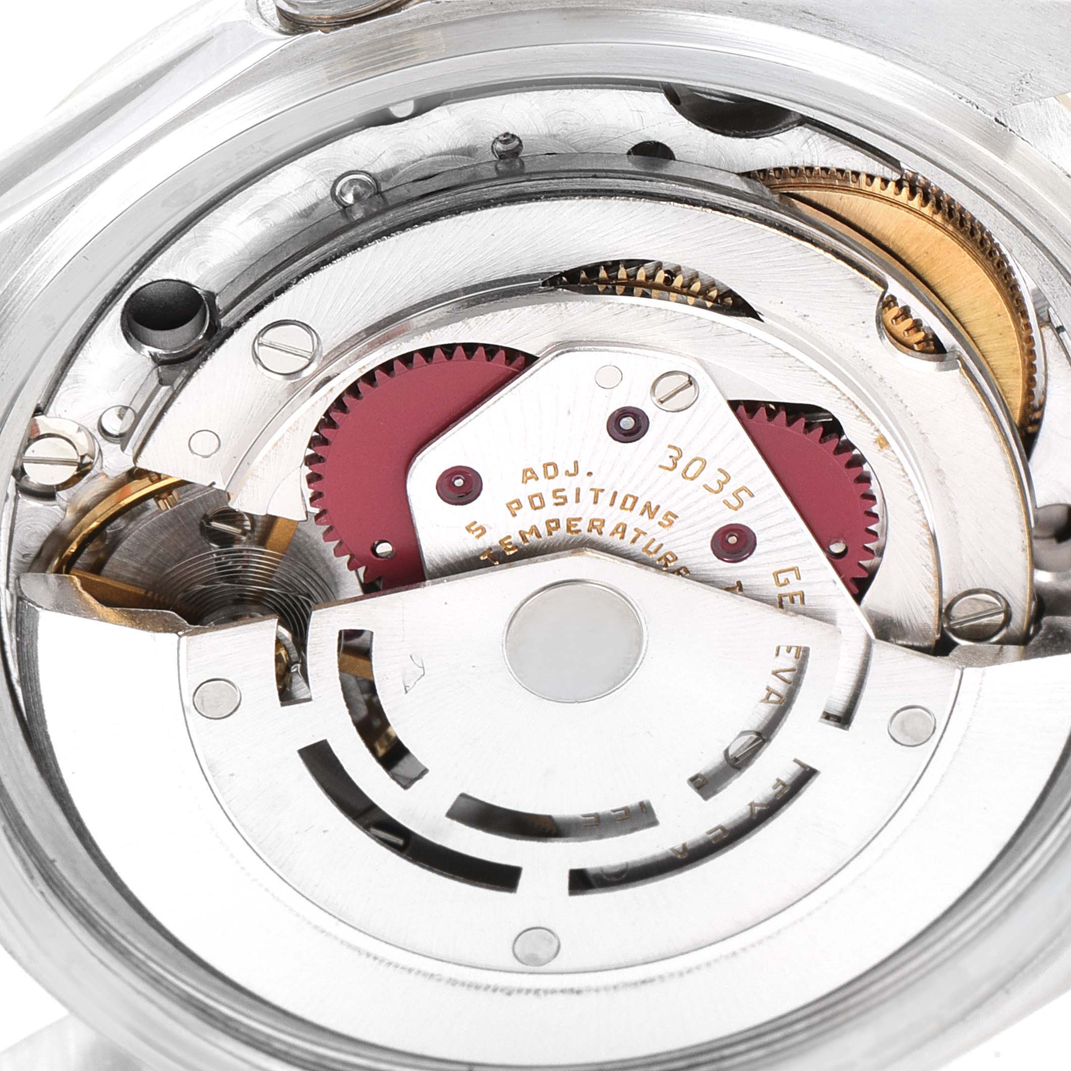 The image shows a close-up of the internal movement mechanism of a Vintage Collection Rolex watch, highlighting gears and components.