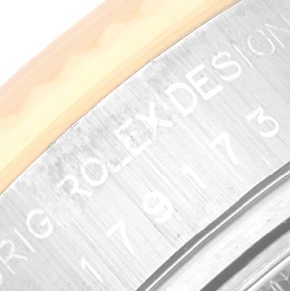 This close-up image of a Rolex Datejust 179173 Women's Steel and Gold (two tone) Champagne Dial 179173 Women's Steel and Gold (two tone) Champagne Dial watch shows part of the bezel and engraved lettering on the side.
