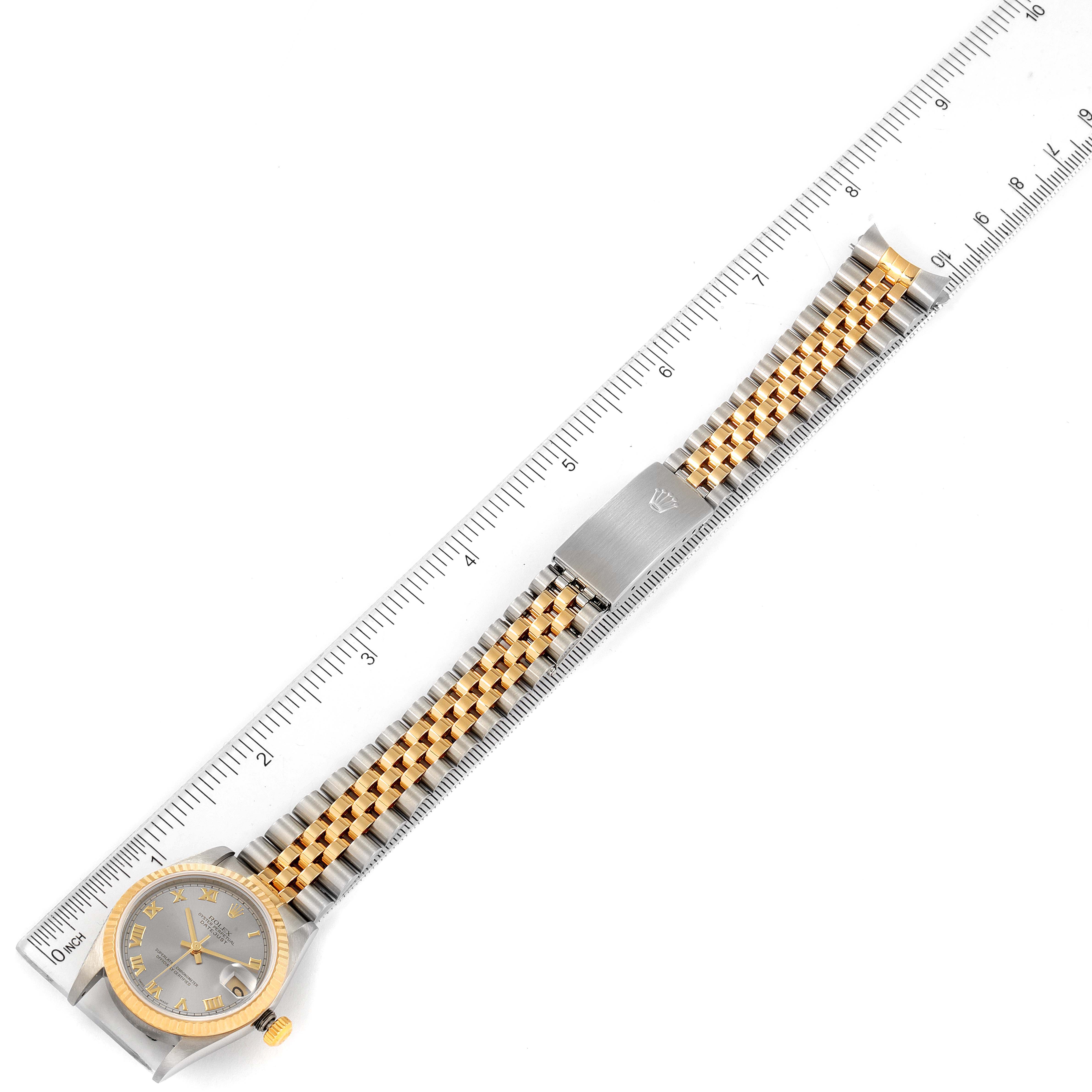 This image shows an overhead view of a Rolex Mid-Size 78273 Women's Steel and Gold (two tone) Grey Dial 78273 Women's Steel and Gold (two tone) Grey Dial watch, displaying its face, bracelet, and clasp alongside a ruler.