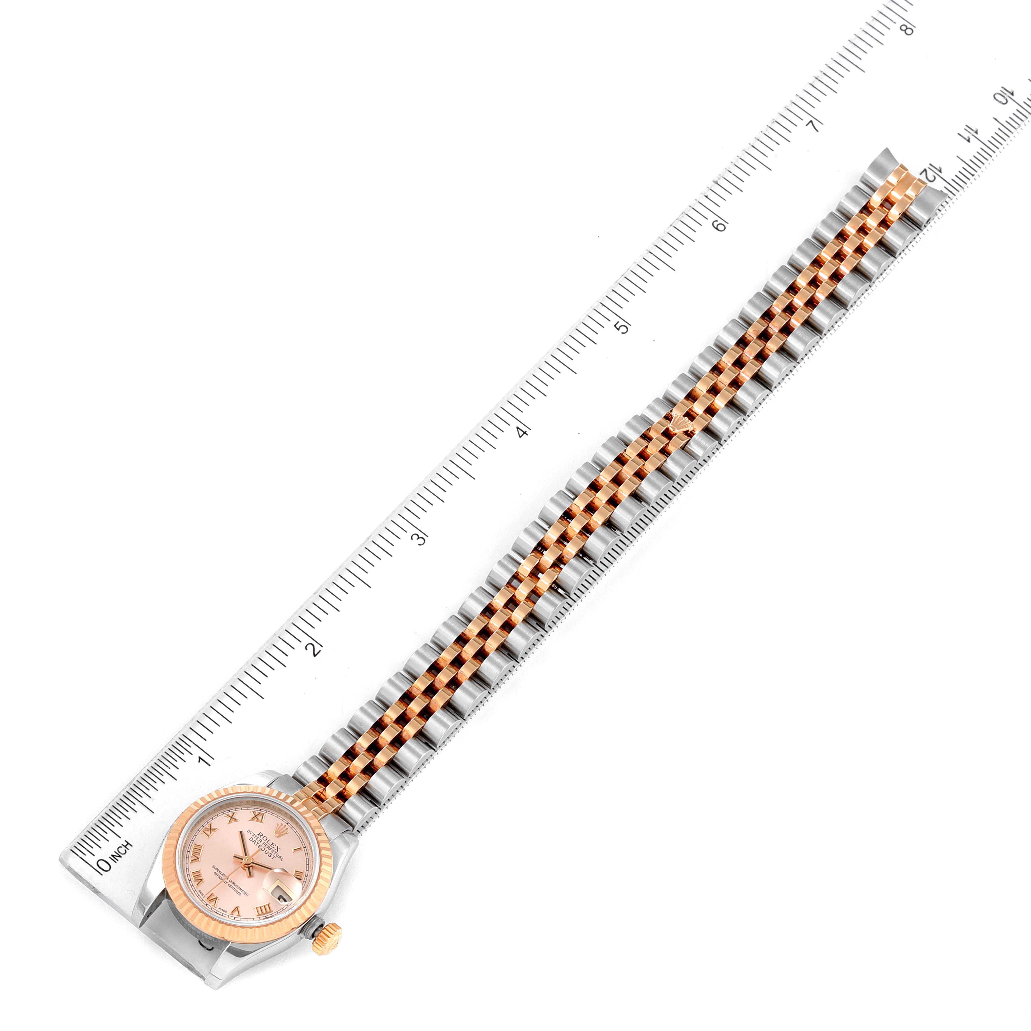 The image shows a top view of a Rolex Datejust 179171 Women's Steel and Gold (two tone) Pink Dial 179171 Women's Steel and Gold (two tone) Pink Dial watch, displaying the face, bezel, and bracelet, with a ruler in the background for scale.