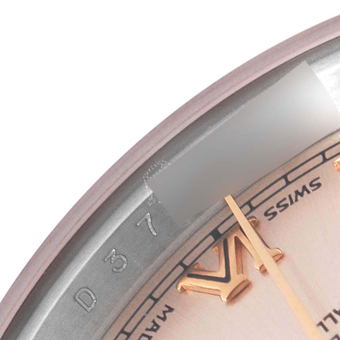 This close-up image shows the edge of the dial and the rehaut of a Rolex Datejust 179171 Women's Steel and Gold (two tone) Pink Dial 179171 Women's Steel and Gold (two tone) Pink Dial watch, featuring part of a Roman numeral and Swiss marking.