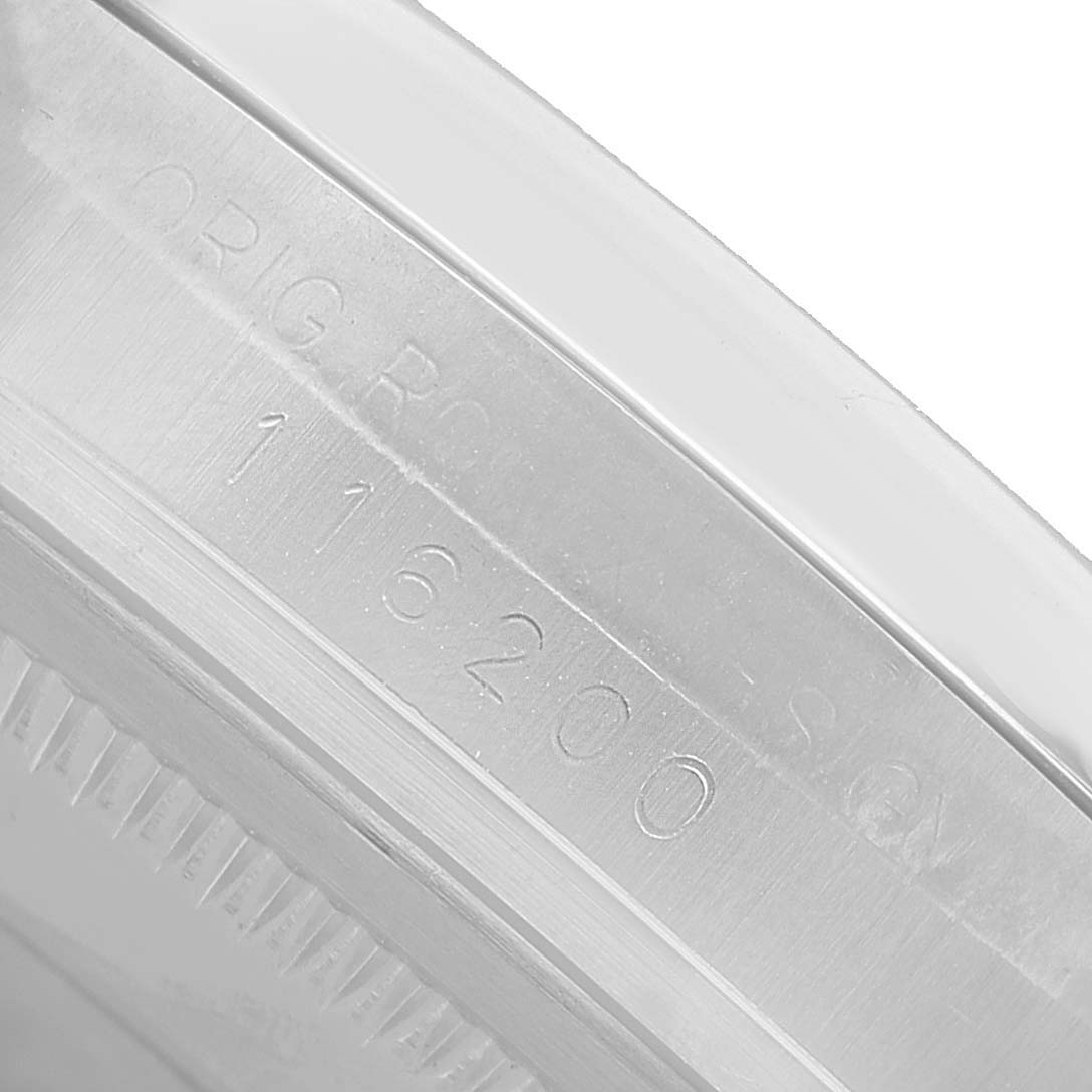 The image shows a close-up of the engraved inner bezel of a Rolex Datejust 116200 Men's Stainless Steel Silver Dial watch.