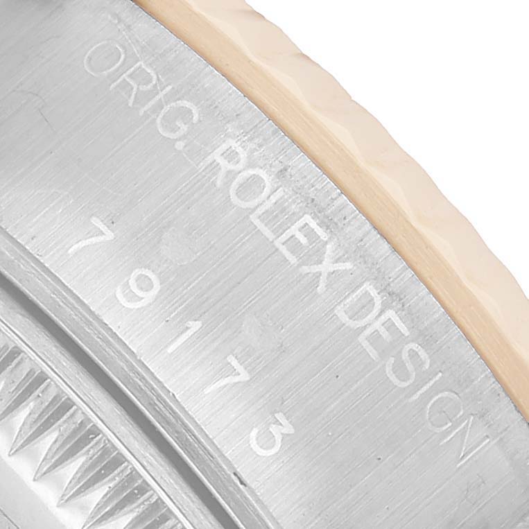 This image shows a close-up of the side of a Rolex Datejust 79173 Women's Steel and Gold (two tone) Black Dial, featuring "ORIG. ROLEX DESIGN" engraving and part of the bezel.