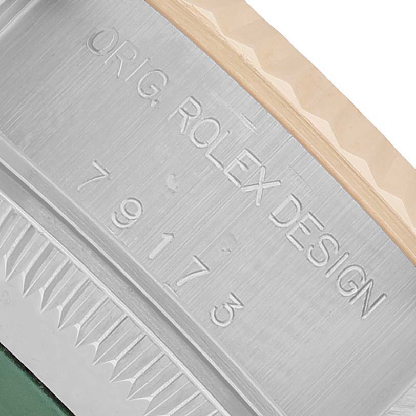 The image shows an angled view of the Rolex Datejust 79173 Women's Steel and Gold (two tone) Champagne Dial model's side, highlighting the engraved "ORIG. ROLEX DESIGN" with the reference number.