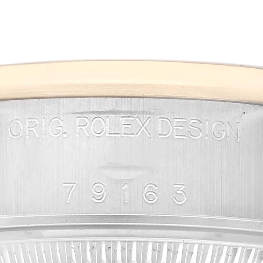 This image shows a close-up of the engraved case edge of a Rolex Datejust 79163 Women's Steel and Gold (two tone) Silver Dial 79163 Women's Steel and Gold (two tone) Silver Dial model with the design number 79163.