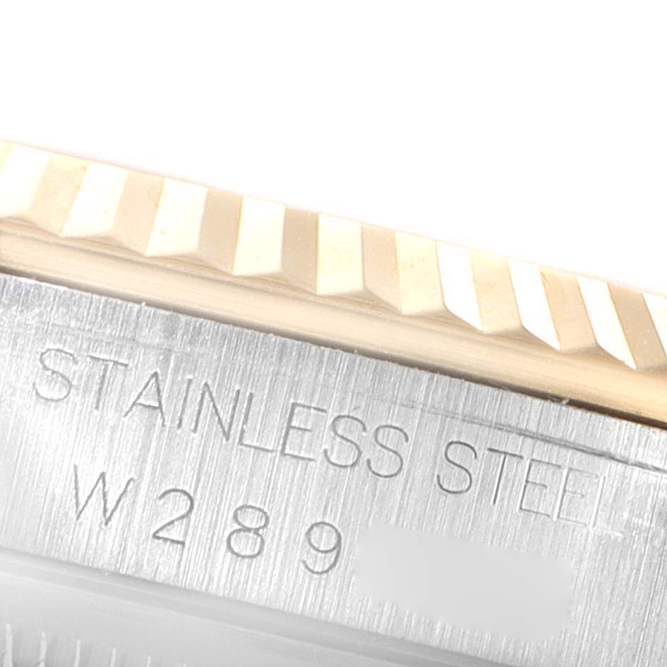 The image shows a close-up of the side of a Rolex Datejust 16233 Men's Steel and Gold (two tone) Champagne Dial 16233 Men's Steel and Gold (two tone) Champagne Dial watch, focusing on the fluted bezel and engraved serial number.