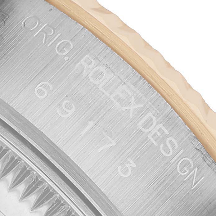 The image shows a close-up of the case edge with engraved text and bezel of the Rolex Datejust 69173 Women's Steel and Gold (two tone) White Dial.