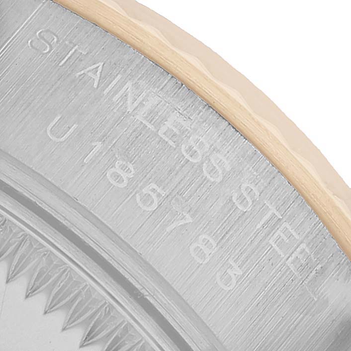 The image shows a close-up of the engraved edge of the Rolex Datejust 69173 Women's Steel and Gold (two tone) White Dial watch case, highlighting its serial number and "STAINLESS" marking.