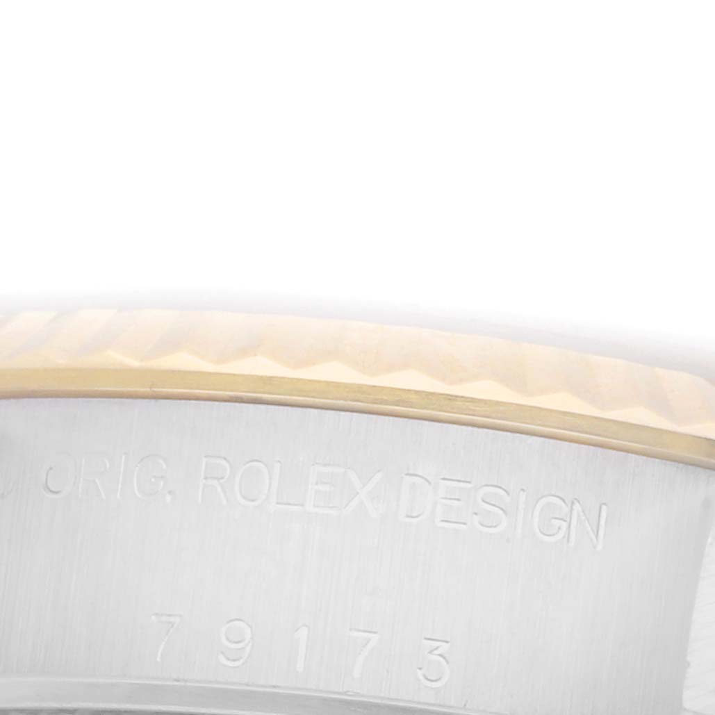 The image shows a close-up of the bezel and case side of a Rolex Datejust 79173 Women's Steel and Gold (two tone) White Dial 79173 Women's Steel and Gold (two tone) White Dial, highlighting engraving details.
