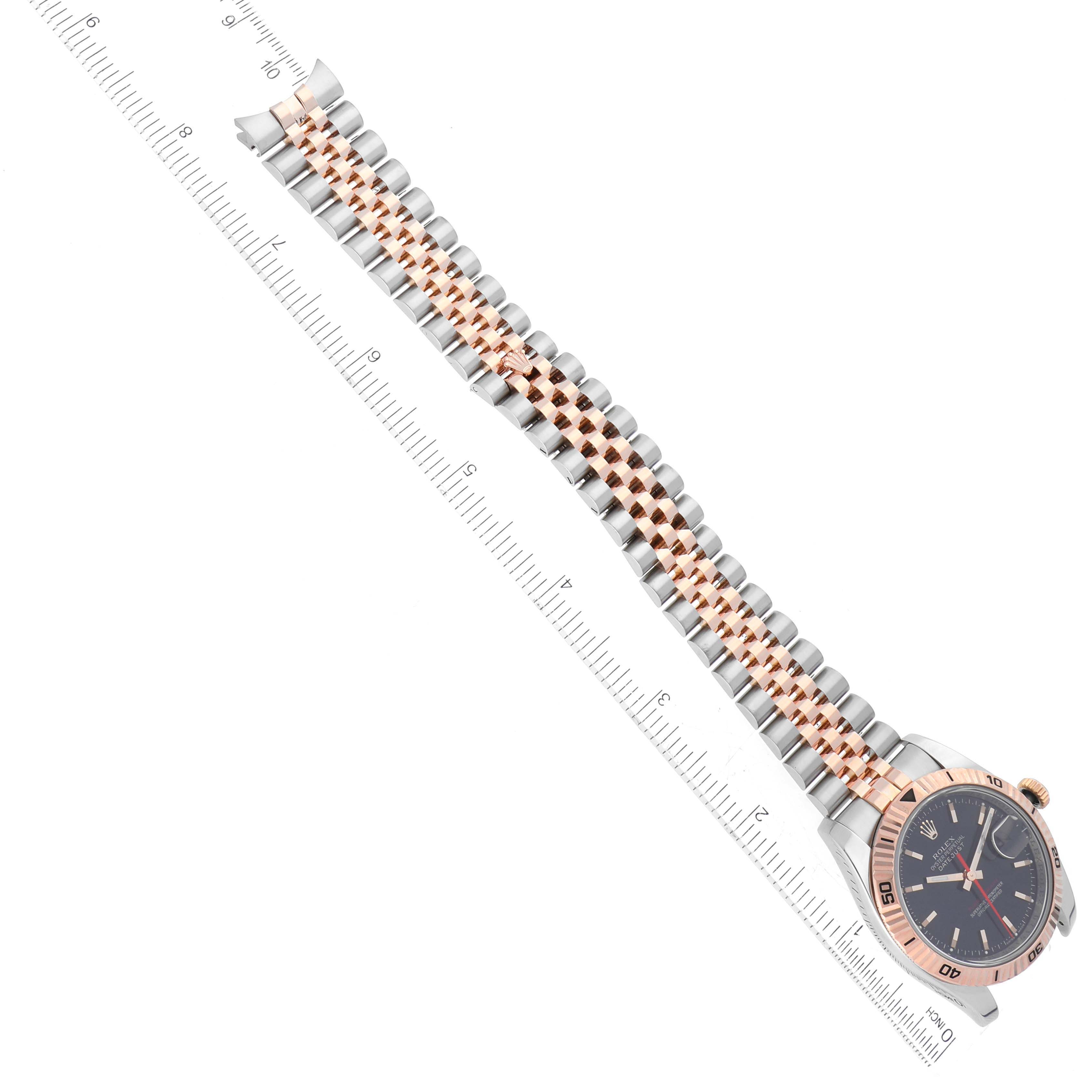 The image shows a Rolex Turn-o-Graph 116261 Men's Steel and Gold (two tone) Black Dial 116261 Men's Steel and Gold (two tone) Black Dial watch laid flat, displaying the face, bezel, and two-tone bracelet next to a ruler.