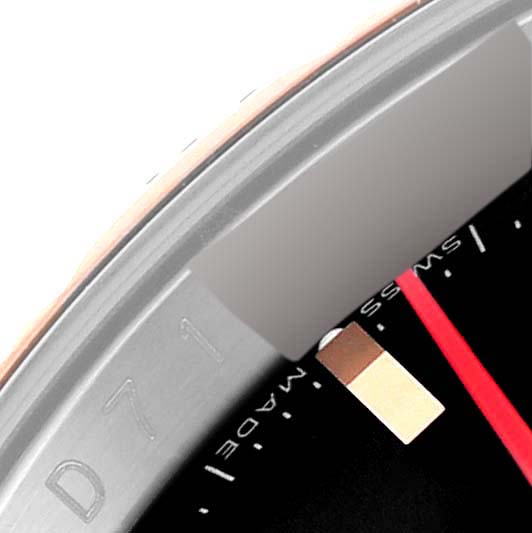 This close-up image of a Rolex Turn-o-Graph 116261 Men's Steel and Gold (two tone) Black Dial 116261 Men's Steel and Gold (two tone) Black Dial model shows a portion of the bezel, dial, and red second hand.