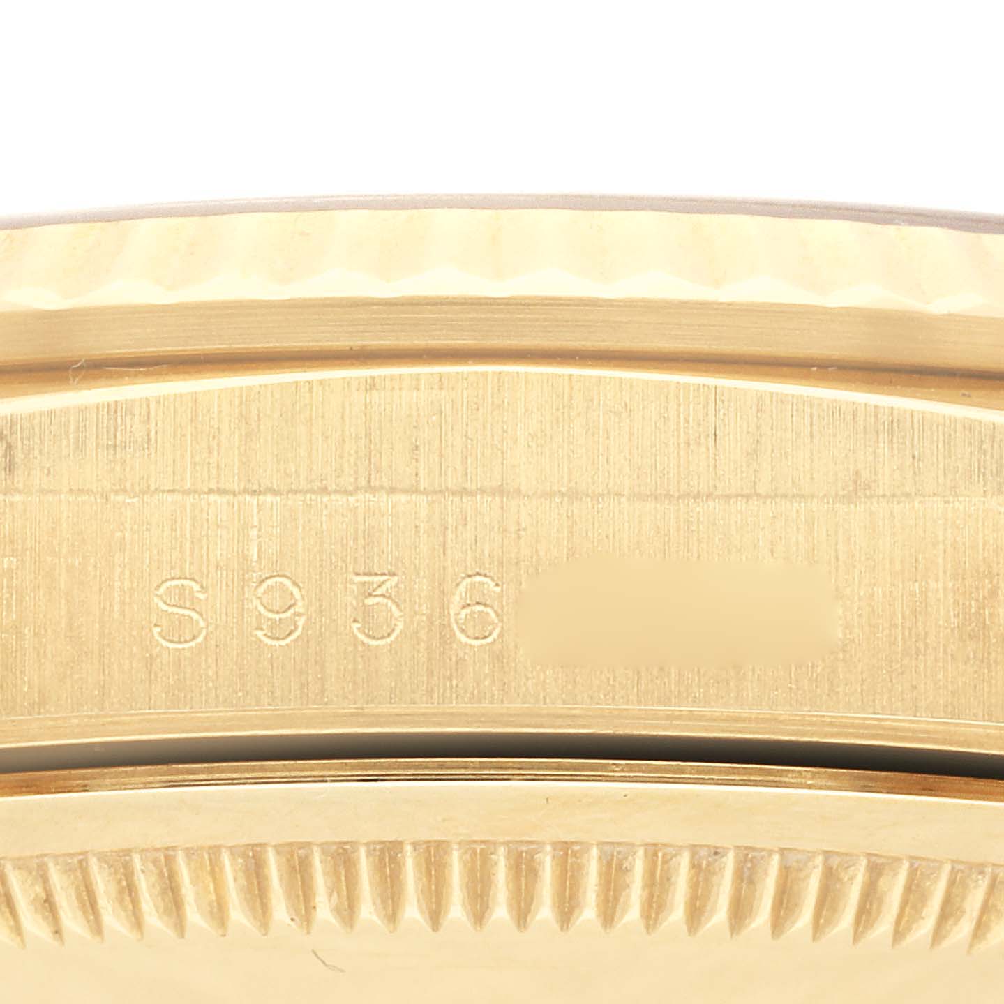 This image shows a close-up of the engraved serial number on a gold Rolex President 18238 Men
s Yellow Gold Champagne Dial 18238 Men
s Yellow Gold Champagne Dial model watch, focusing on the bezel and case.