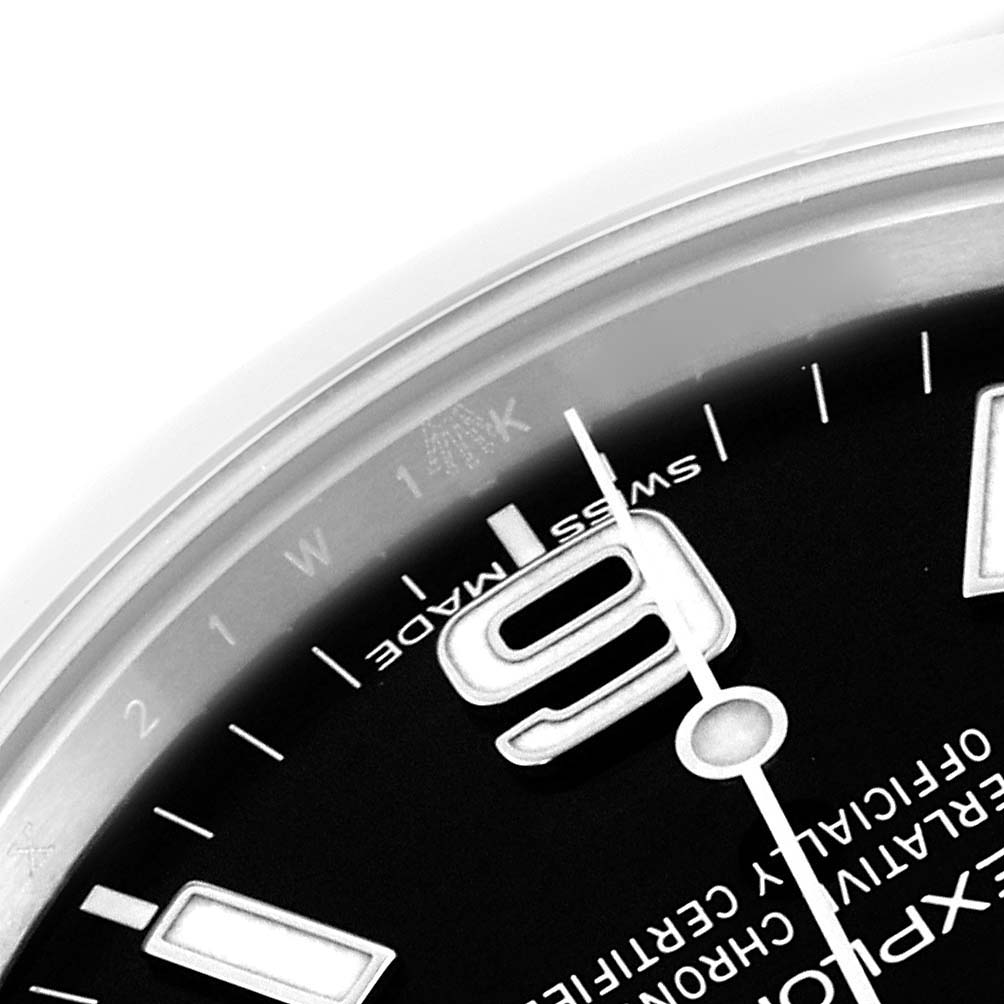 This close-up of the Rolex Explorer 214270 Men's Stainless Steel Black Dial 214270 Men's Stainless Steel Black Dial watch shows the 9 o'clock marker, the minute hand, and part of the "Swiss Made" text on the dial.