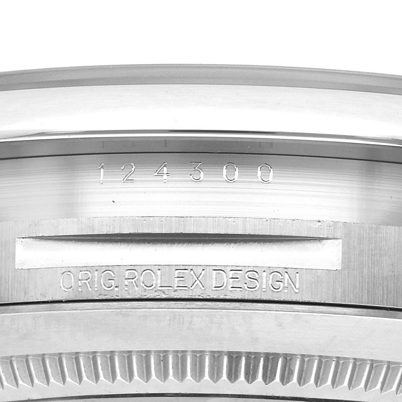 The image shows the side view of a Rolex Oyster Perpetual 124300 Men's Stainless Steel Black Dial 124300 Men's Stainless Steel Black Dial watch, focusing on the engraved model number and design markings.