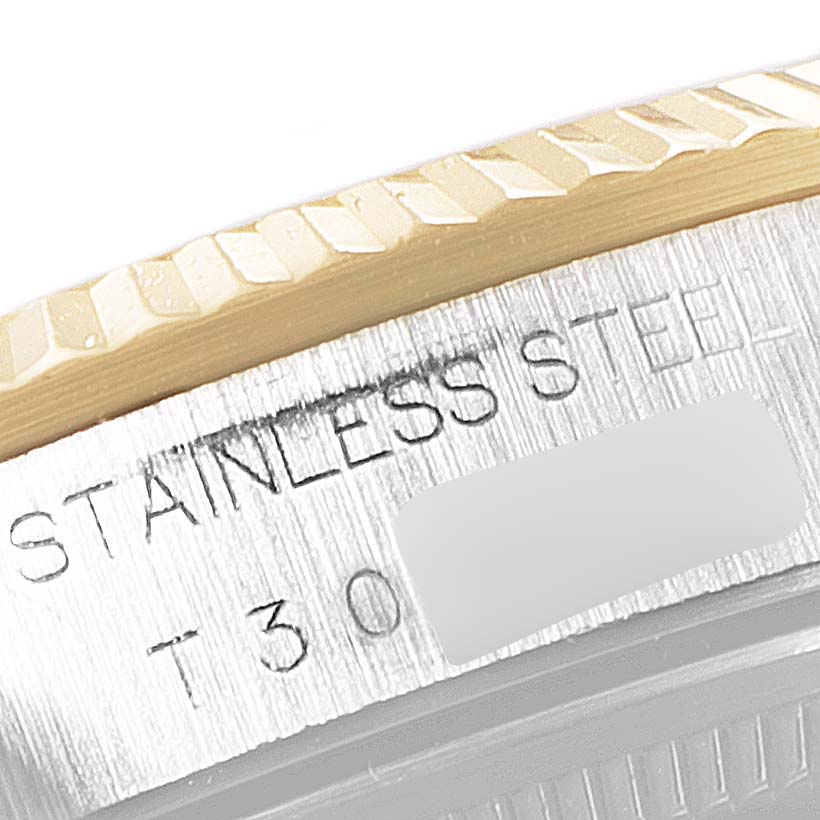 This close-up image of a Rolex Oyster Perpetual 14233 Men's Steel and Gold (two tone) Champagne Dial 14233 Men's Steel and Gold (two tone) Champagne Dial watch shows the side engraving and part of the bezel.