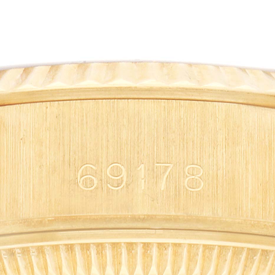 The image shows a close-up of the engraved side of the Rolex President 69178 Women's Yellow Gold Champagne Dial 69178 Women's Yellow Gold Champagne Dial model, focusing on the bezel and serial number.