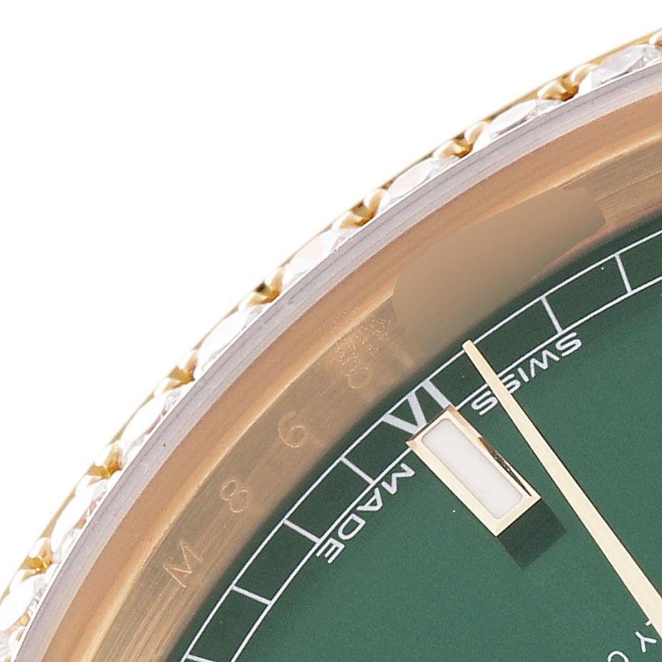 This close-up of the Rolex President 118388 Men's Yellow Gold Green Dial 118388 Men's Yellow Gold Green Dial watch shows part of the dial, bezel, and the hour hand.