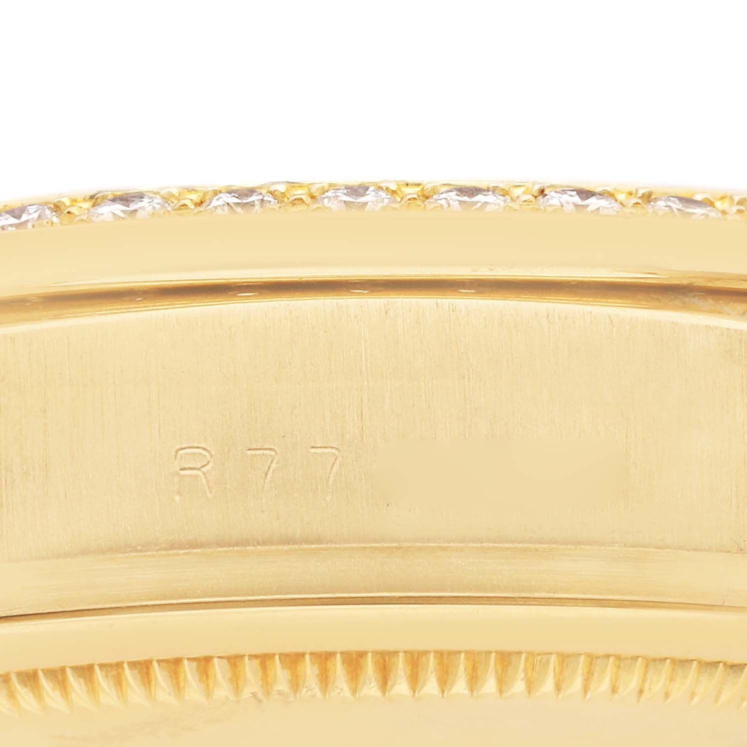 The image shows a close-up of the side of a Rolex President 18048 Men's Yellow Gold Champagne Dial 18048 Men's Yellow Gold Champagne Dial model, focusing on the engraved bezel and edge.