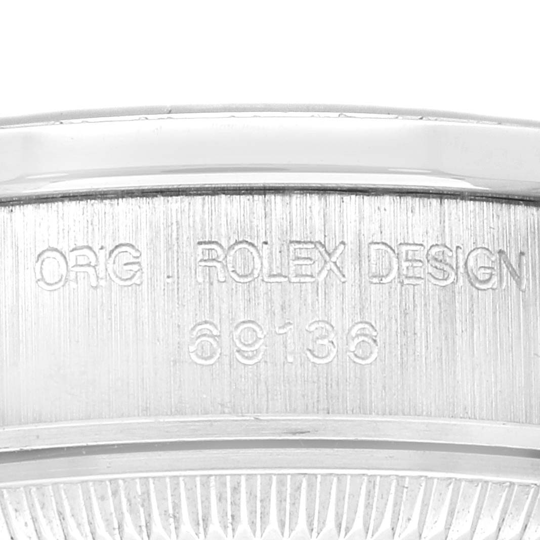 The image shows an up-close view of the case side of a Rolex President 69136G Women's Platinum Silver Dial 69136G Women's Platinum Silver Dial model, highlighting its engraved design and model number.