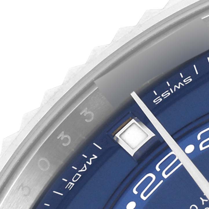 The image shows a close-up of the Rolex Sky-Dweller 326934 Men's Stainless Steel Blue Dial 326934 Men's Stainless Steel Blue Dial's blue dial, hands, and part of the fluted bezel.