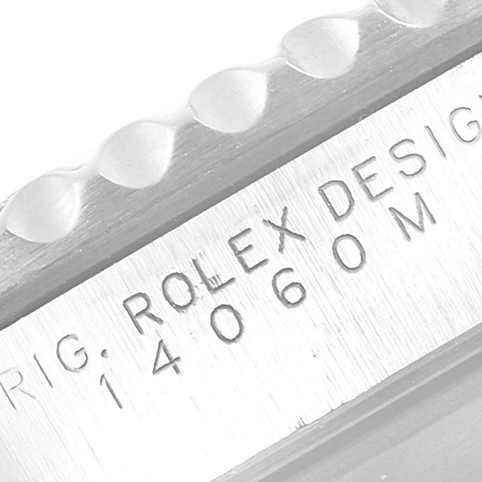 The image shows a close-up of the Rolex Submariner 14060 Men
s Stainless Steel Black Dial 14060 Men
s Stainless Steel Black Dial model
s bezel and engraving on the case side.