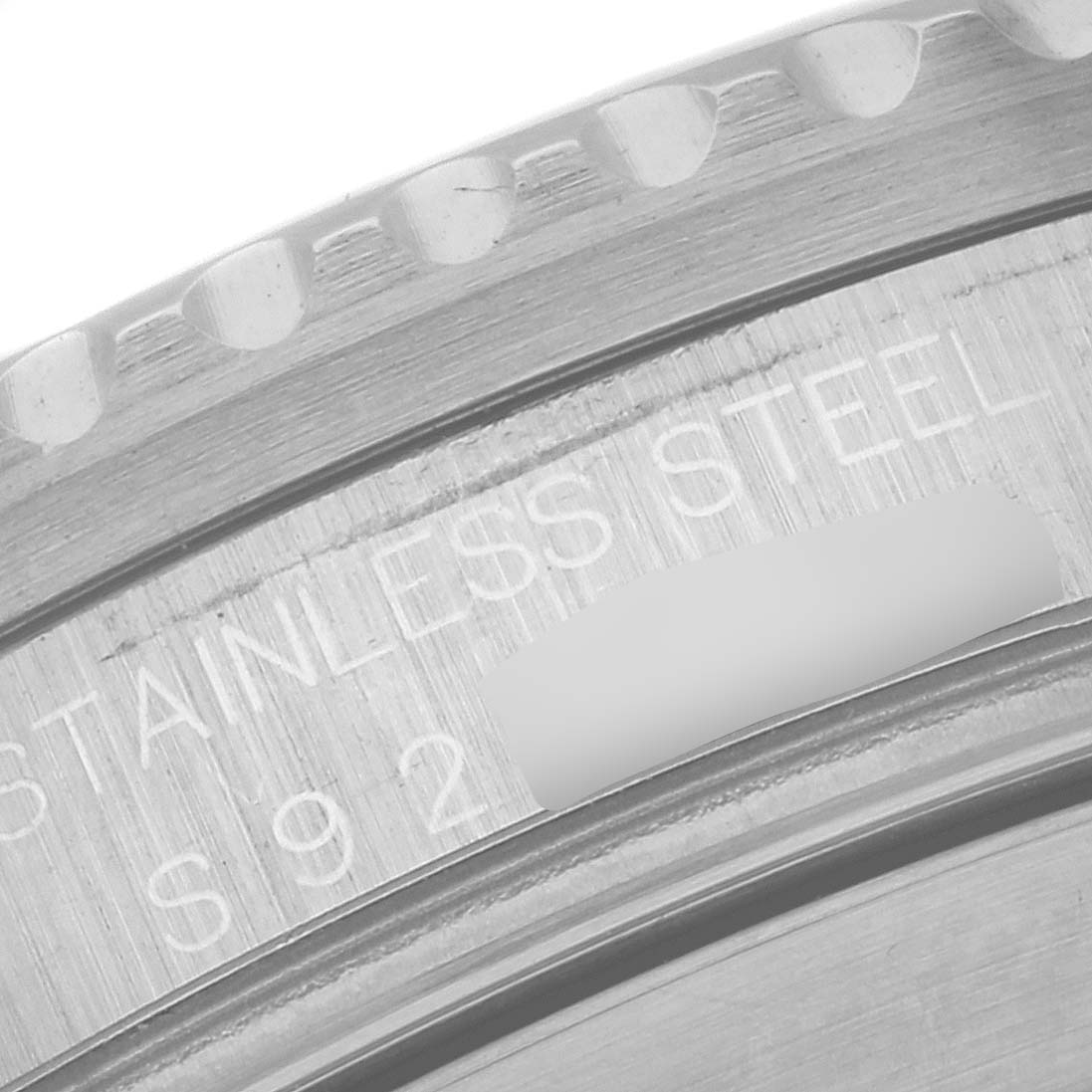 The image shows a close-up of the case back and edge of the bezel of a Rolex Submariner 16610 Men's Stainless Steel Black Dial 16610 Men's Stainless Steel Black Dial model, highlighting the stainless steel material.