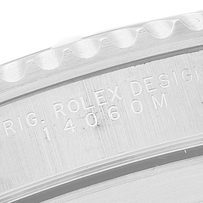 This image shows a close-up view of the engraved text on the side of a Rolex Submariner 14060M Men's Stainless Steel Black Dial 14060M Men's Stainless Steel Black Dial model watch bezel.