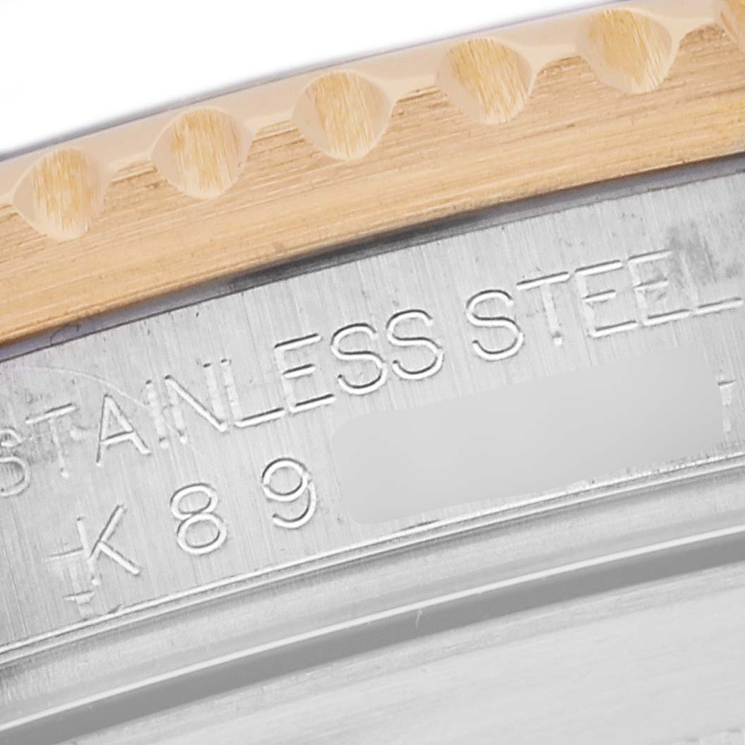 Close-up of a Rolex Submariner 16613LB Men's Steel and Gold (two tone) Champagne Dial 16613LB Men's Steel and Gold (two tone) Champagne Dial's case showing the stainless steel engraving and part of the bezel.