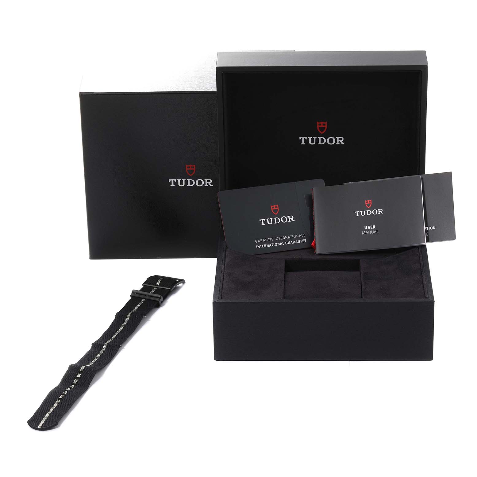 This image shows the Tudor Heritage Black Bay 79210CNU Men's Ceramic Black Dial 79210CNU Men's Ceramic Black Dial watch packaging, including the box, manuals, international guarantee card, and an extra strap.
