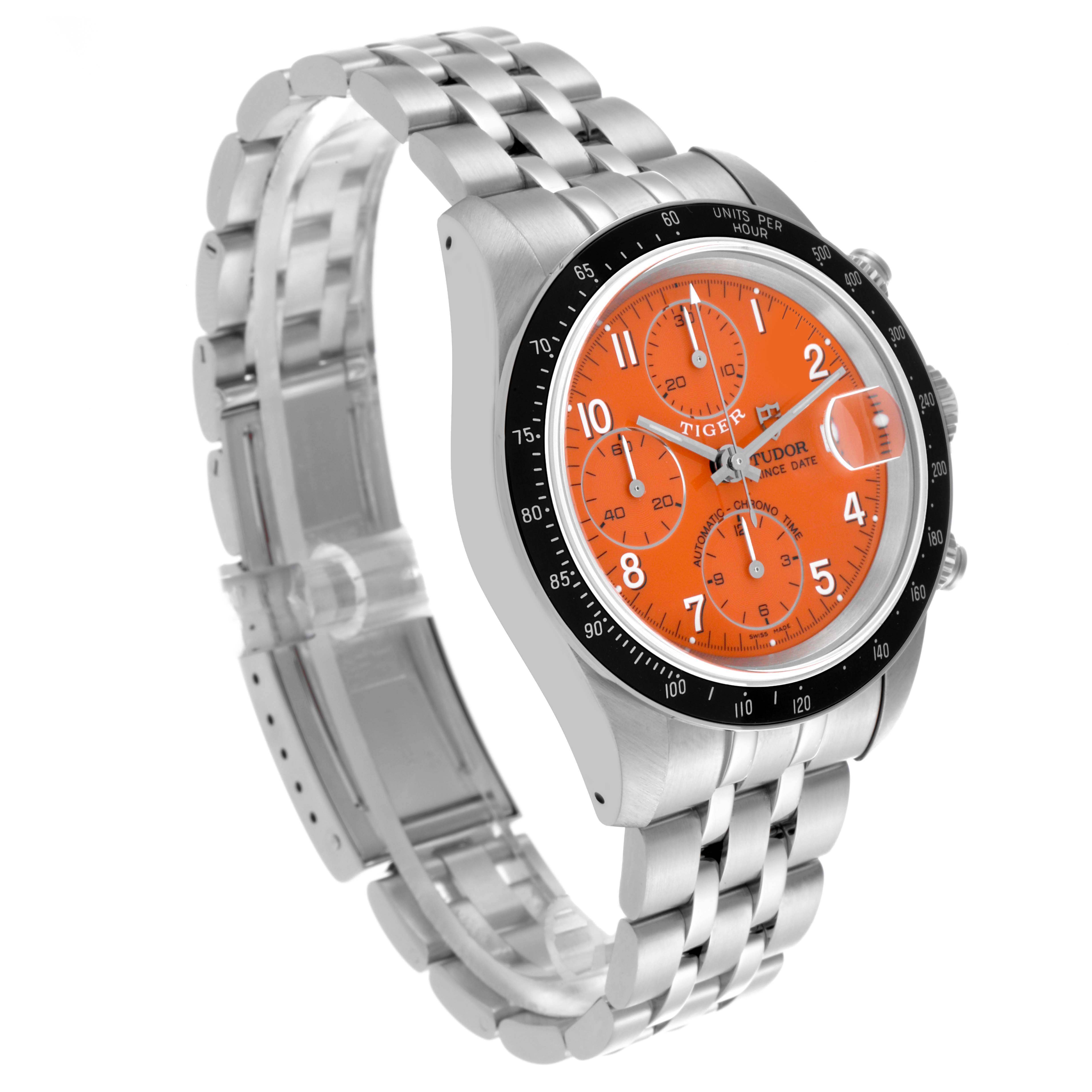 The Tudor Tiger 79260 Men's Stainless Steel Orange Dial 79260 Men's Stainless Steel Orange Dial model watch is shown from a three-quarter angle, highlighting its orange dial, chronograph subdials, and metal bracelet.